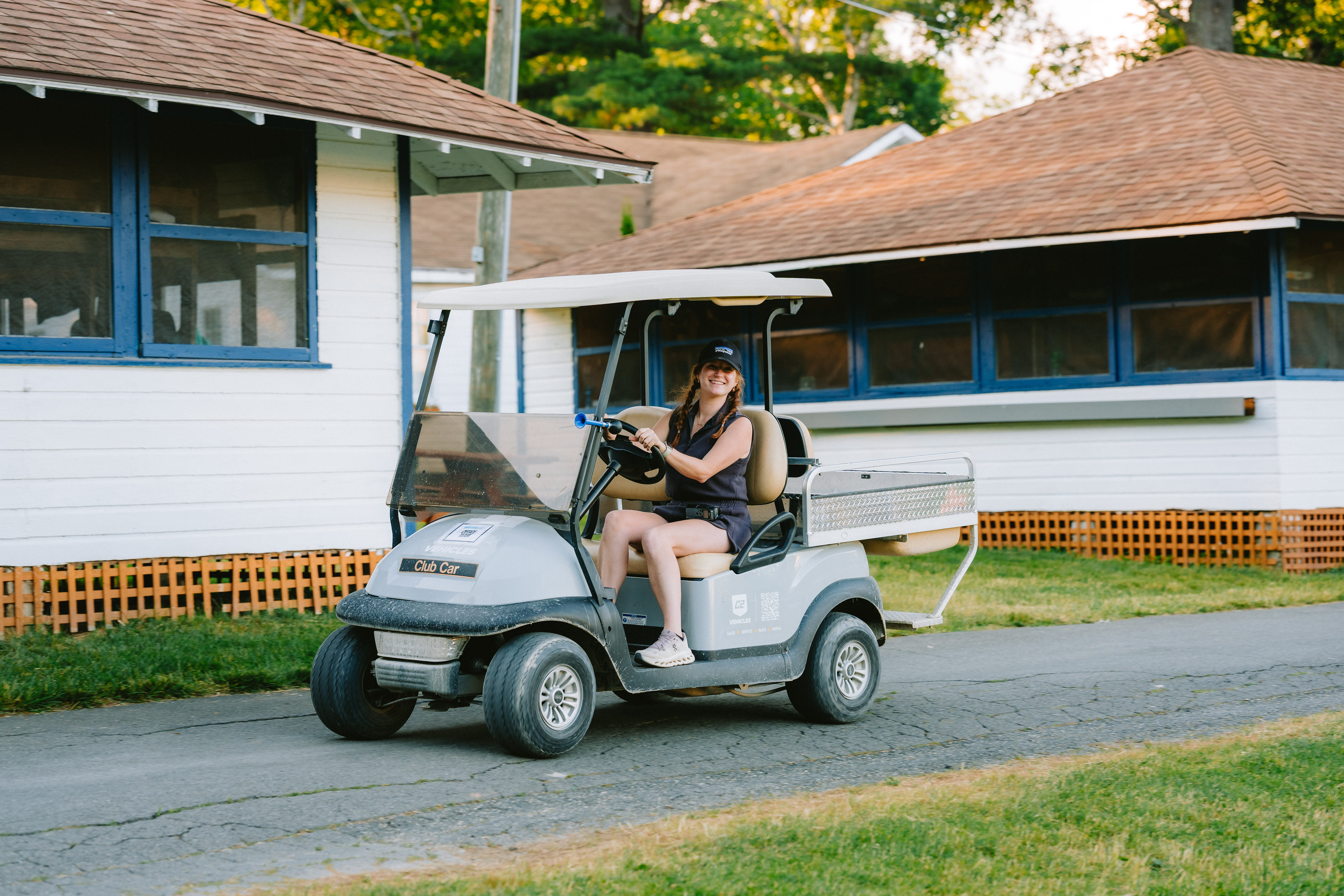 Camp Winadu maintenance staff member driving a utility cart