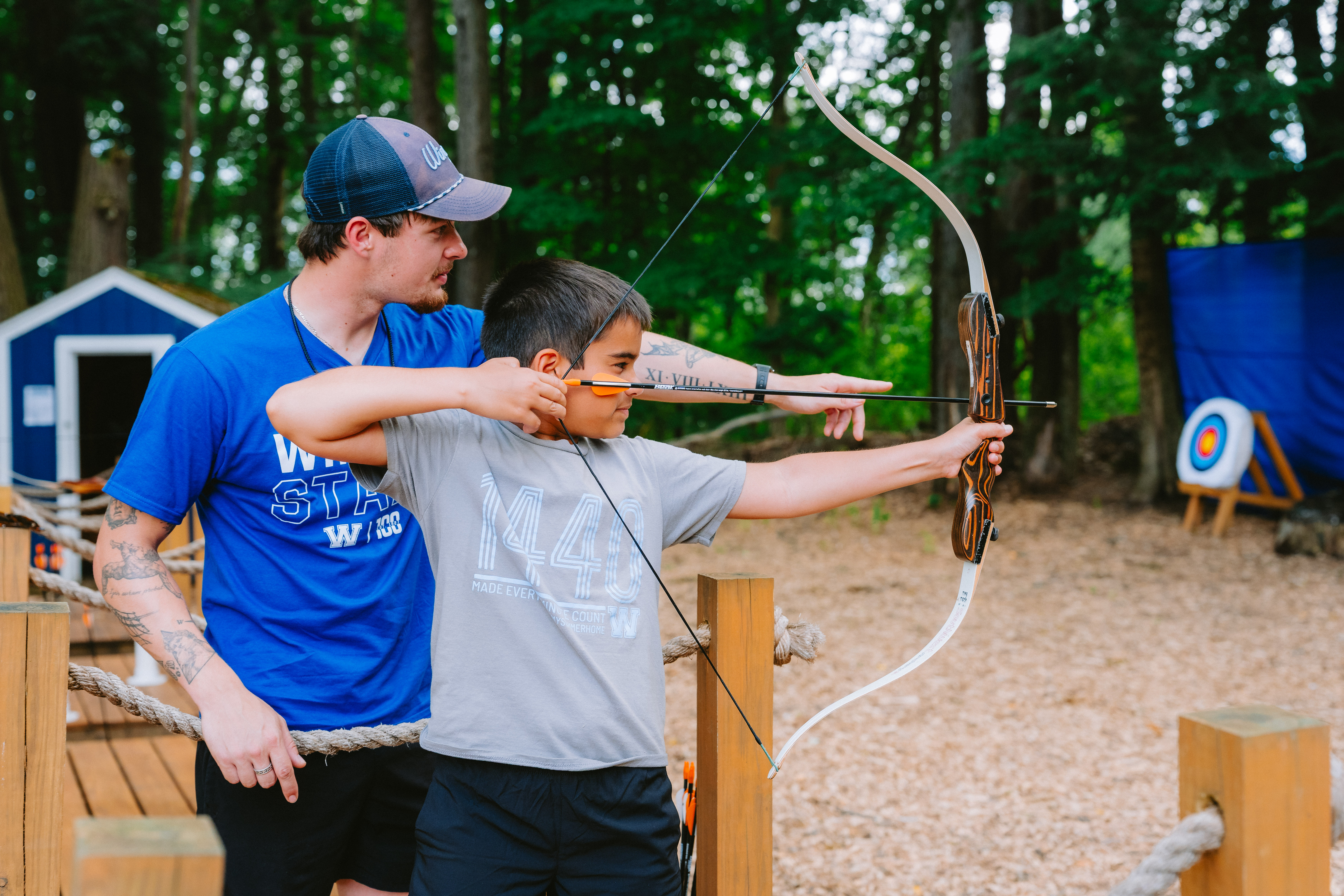 Camp Winadu archery coach teaching a camper