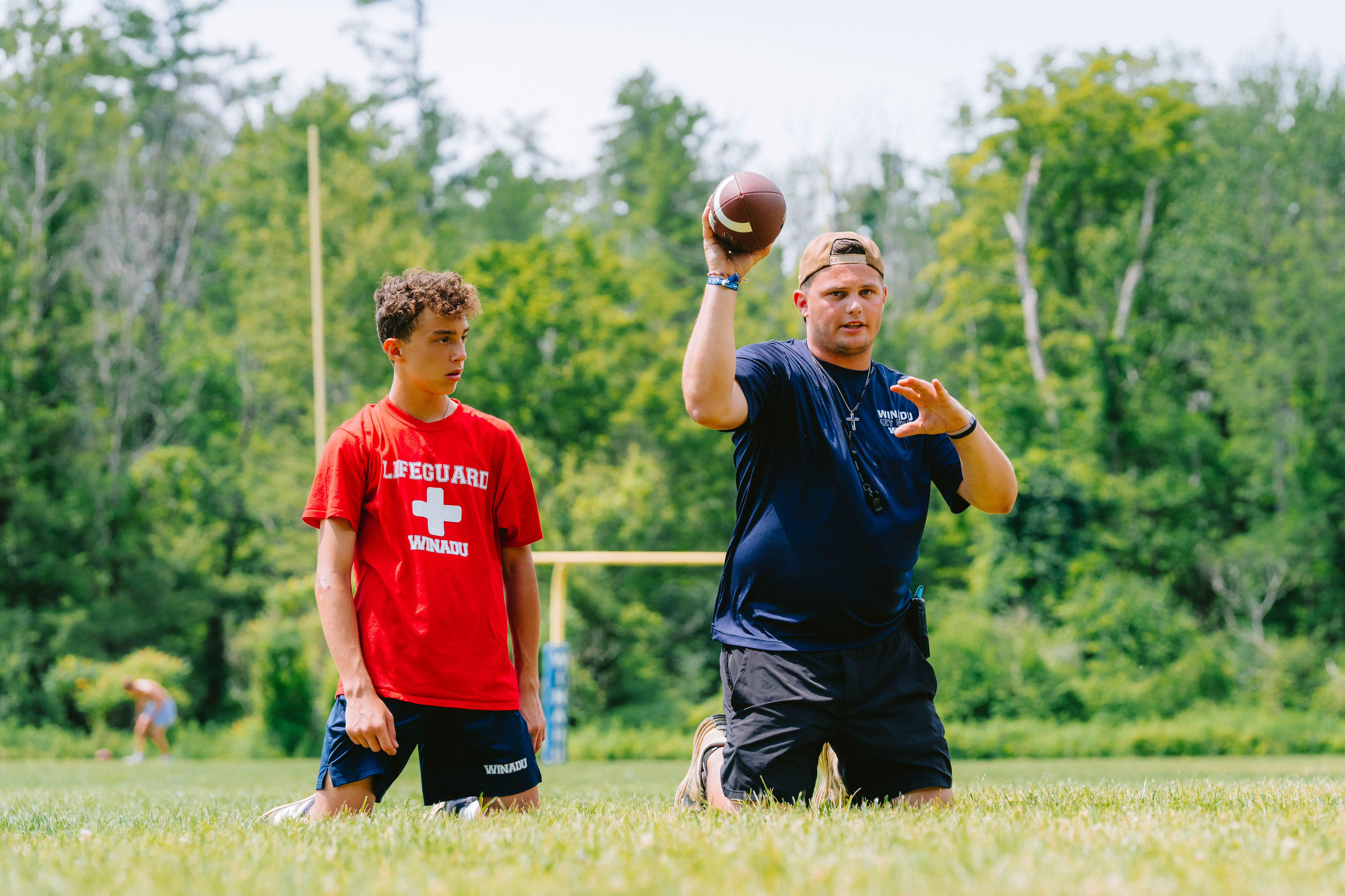 Camp Winadu football coach working with a camper