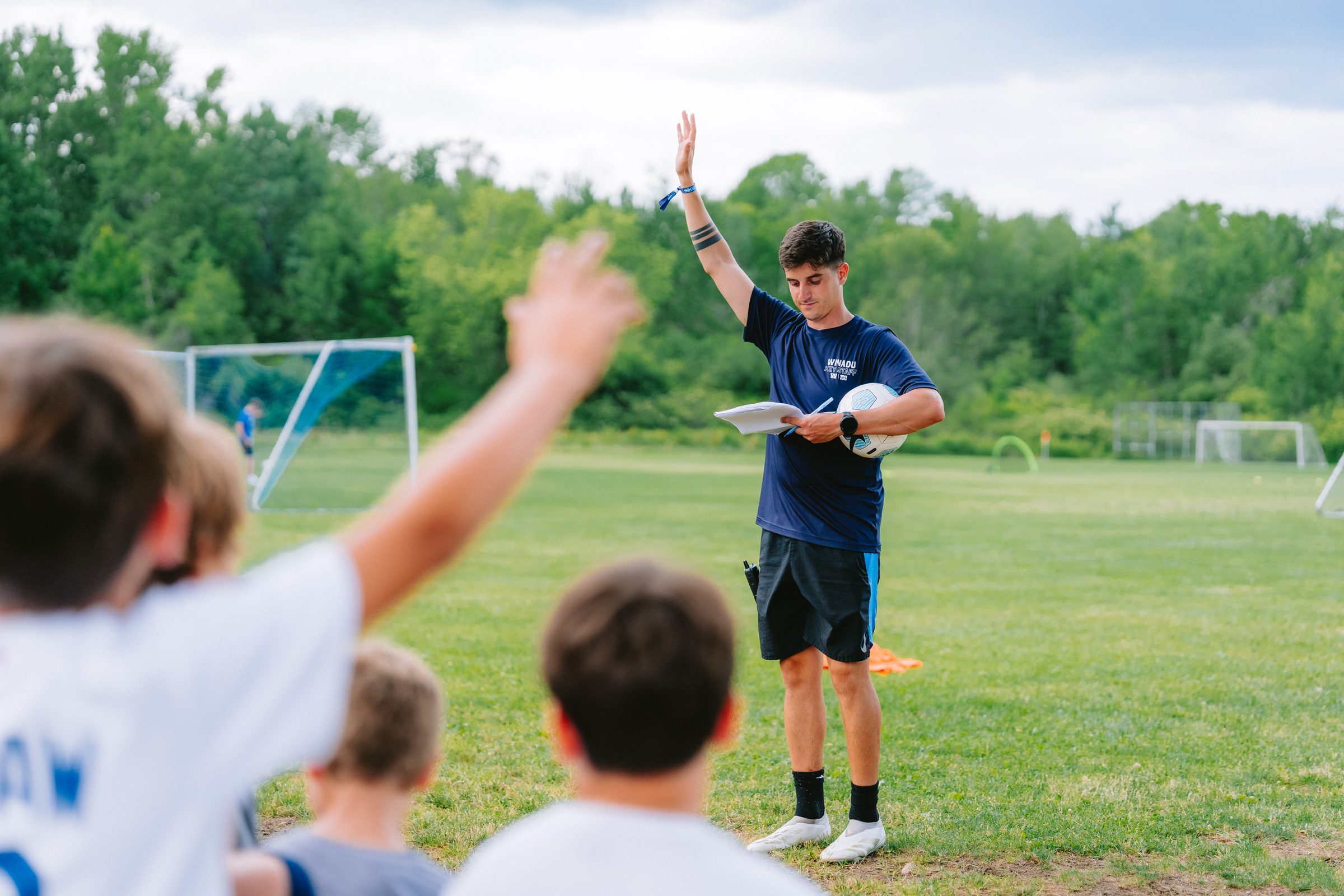 Camp Winadu coach cheering with campers on the field