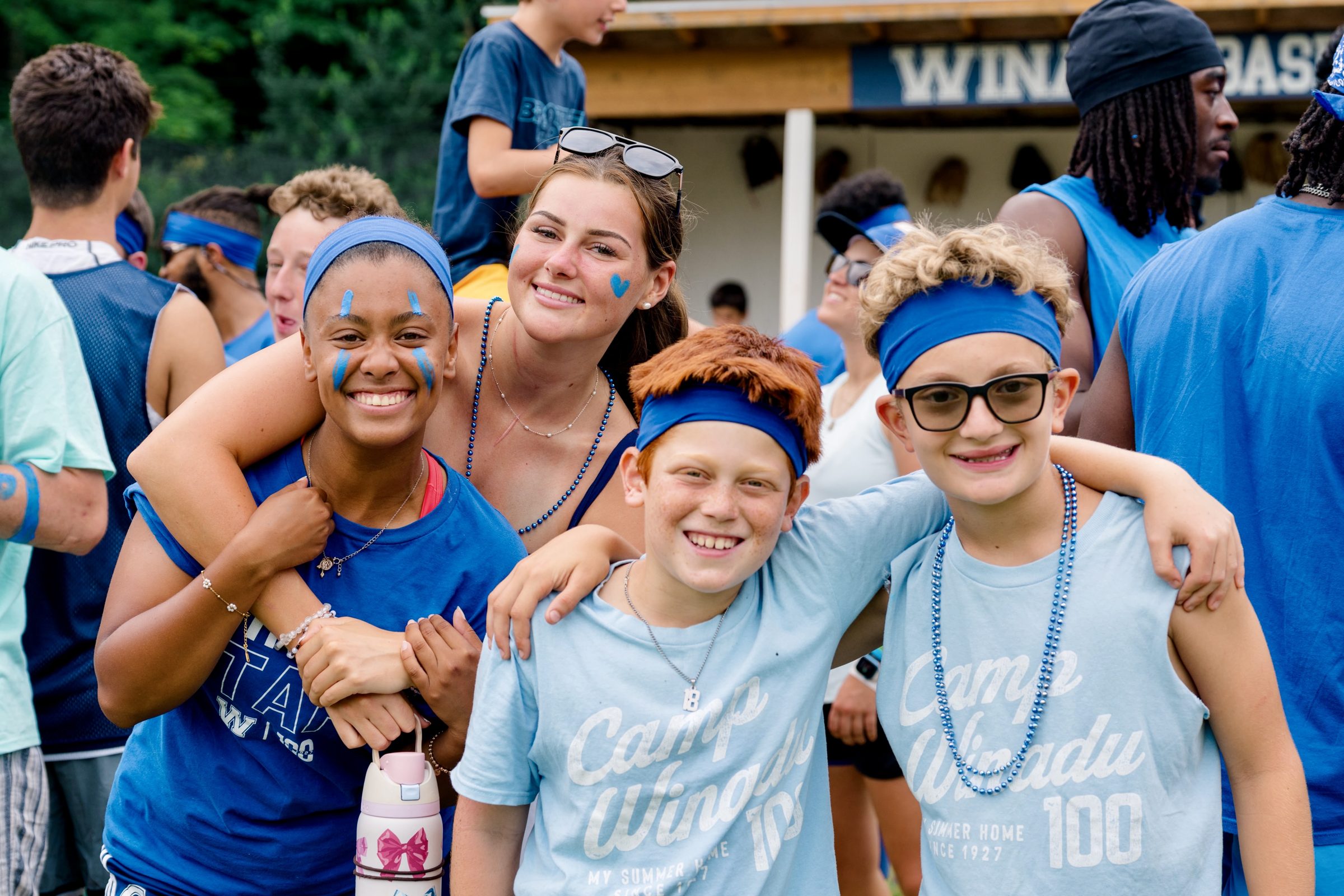 Camp Winadu counselors and campers in blue headbands cheering