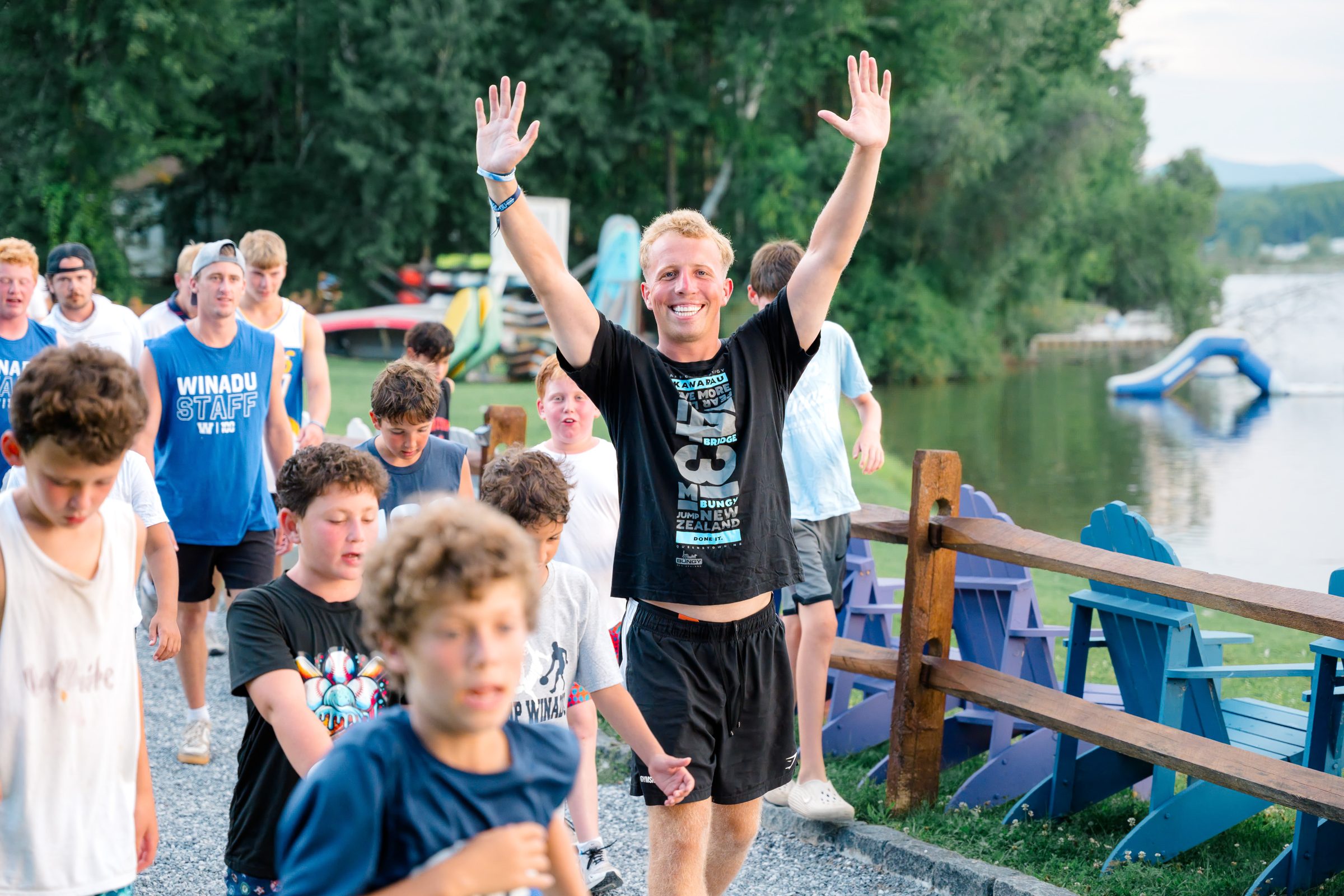 Camp Winadu staff and campers cheering by the lake
