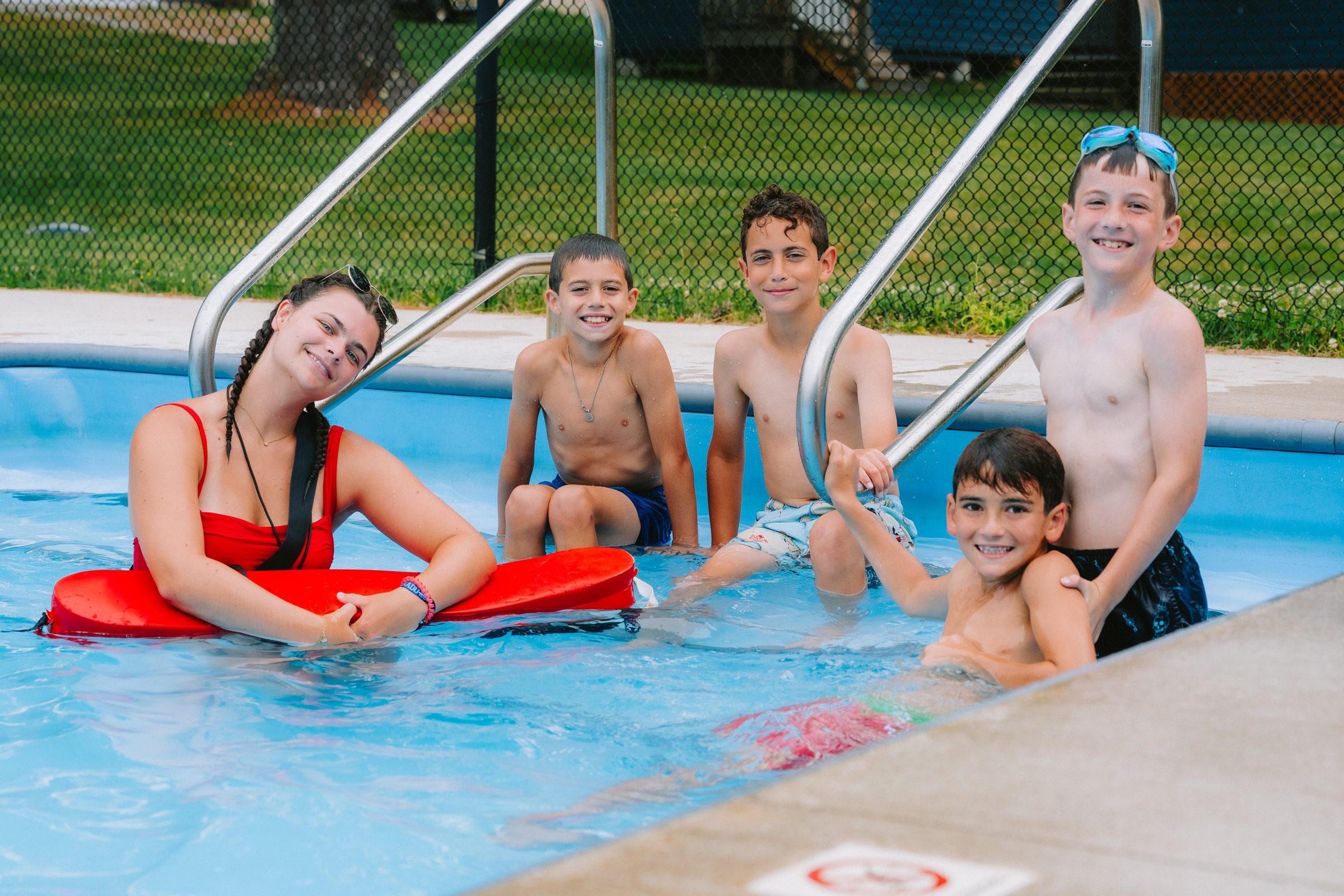 Camp Winadu lifeguard with campers in the pool