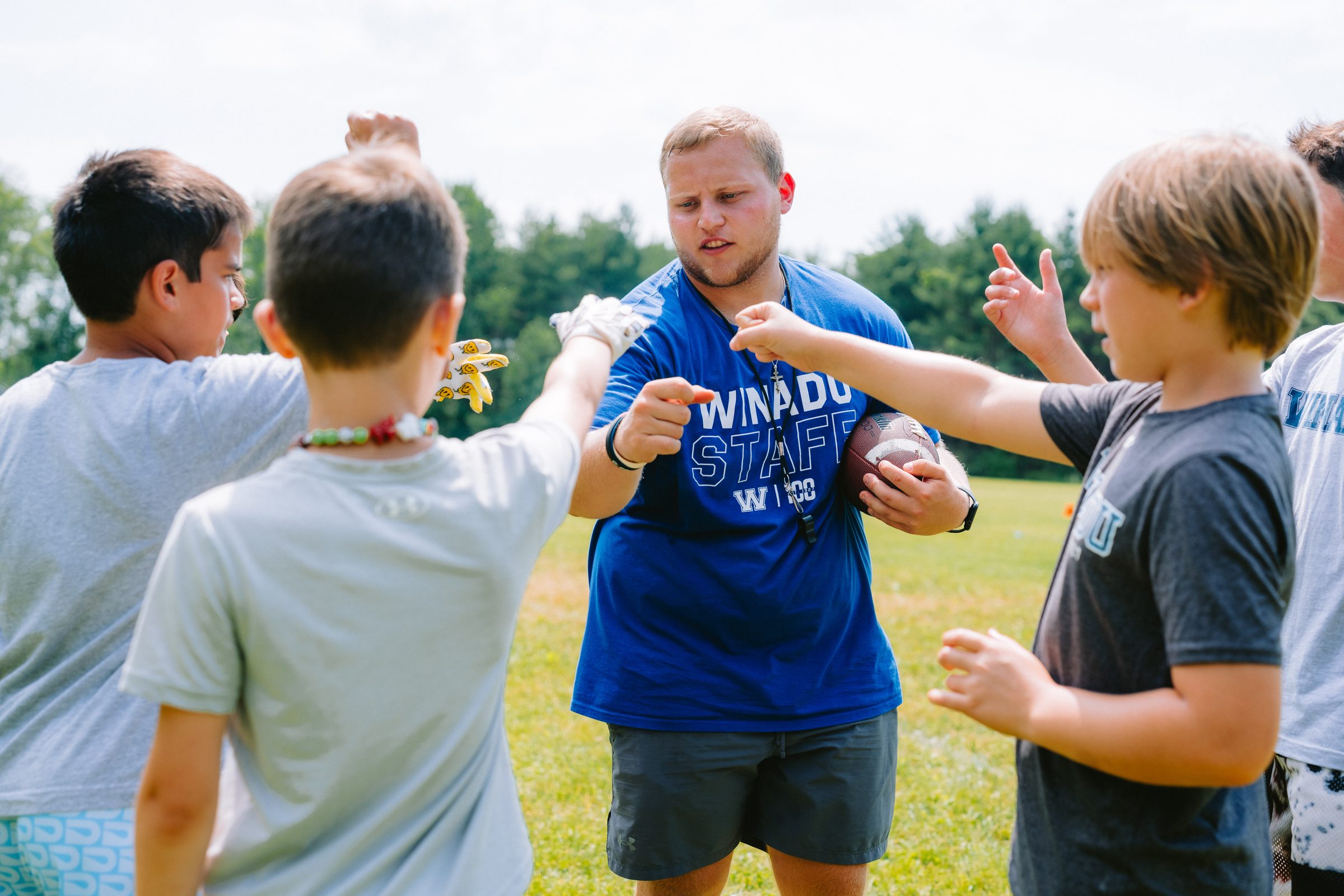 Camp Winadu counselor high-fiving campers on the field