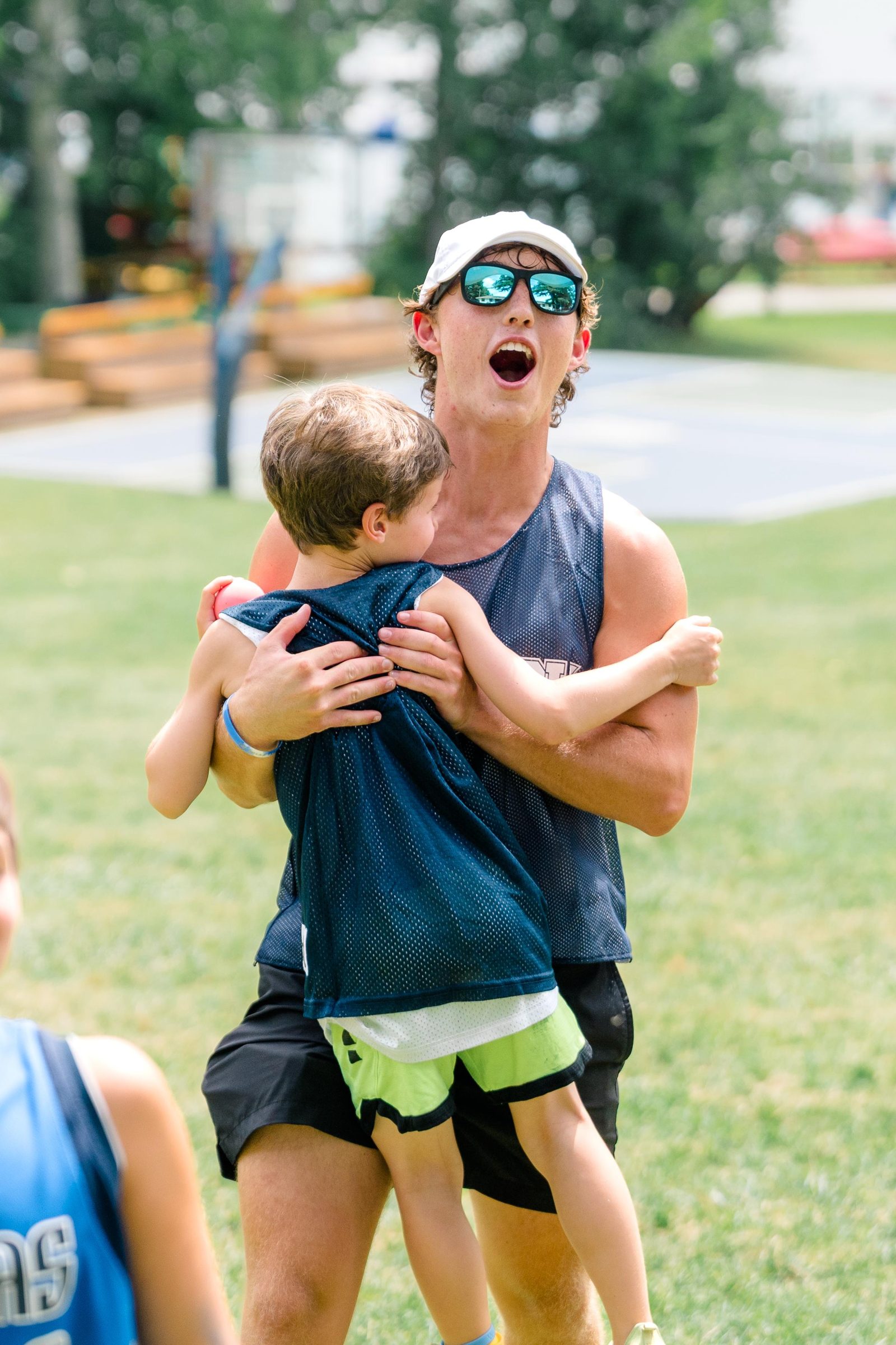 Camp Winadu counselor carrying a happy camper