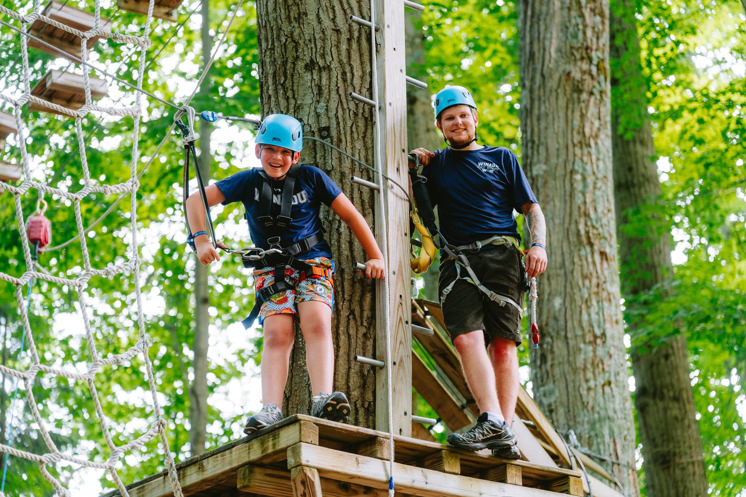 Camp Winadu ropes instructor and a camper on a high ropes platform