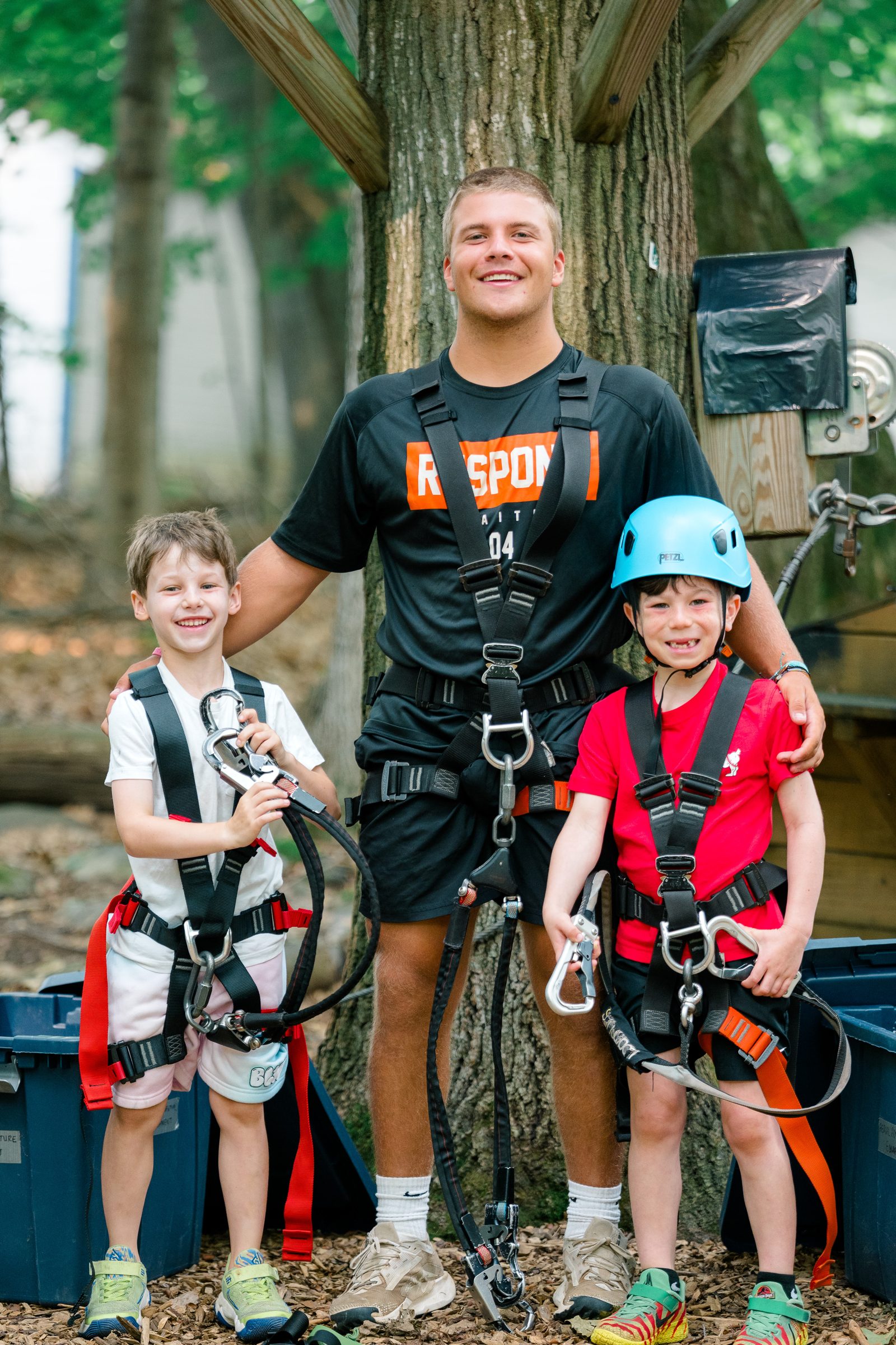 Camp Winadu ropes instructor with two campers in harnesses