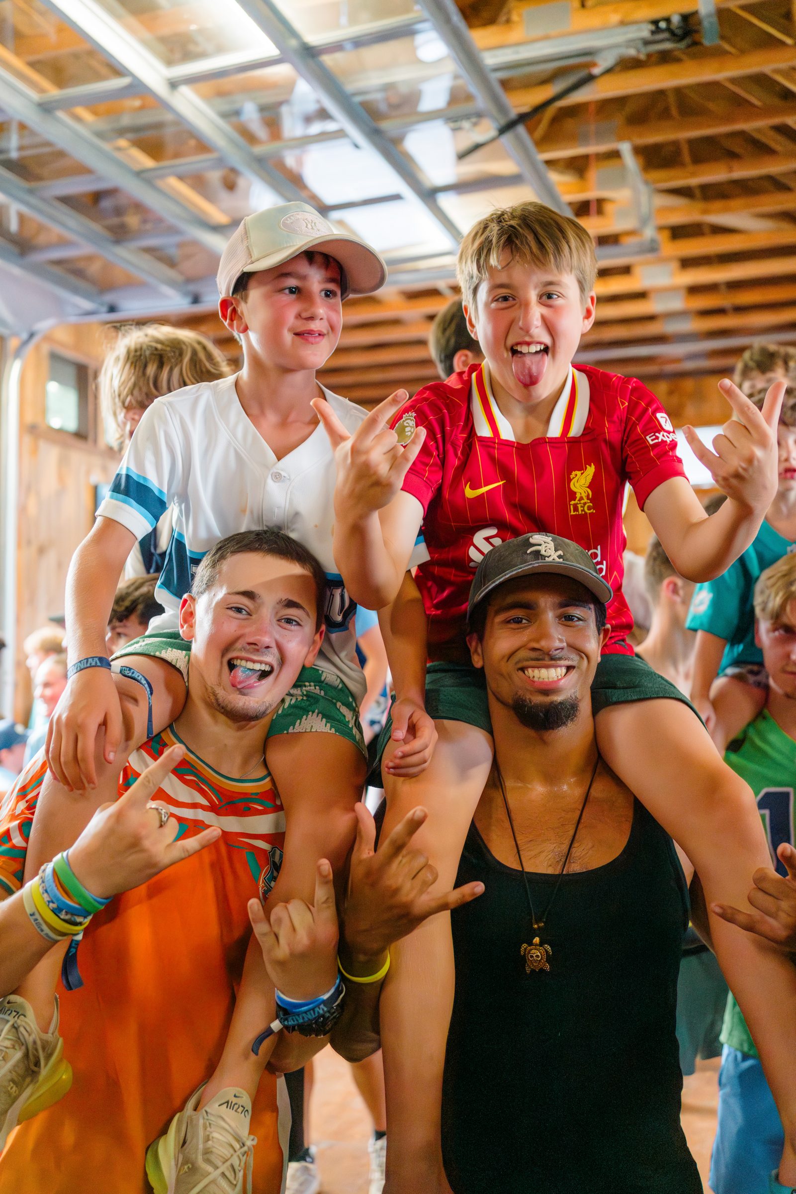 Counselors carrying cheering campers on their shoulders