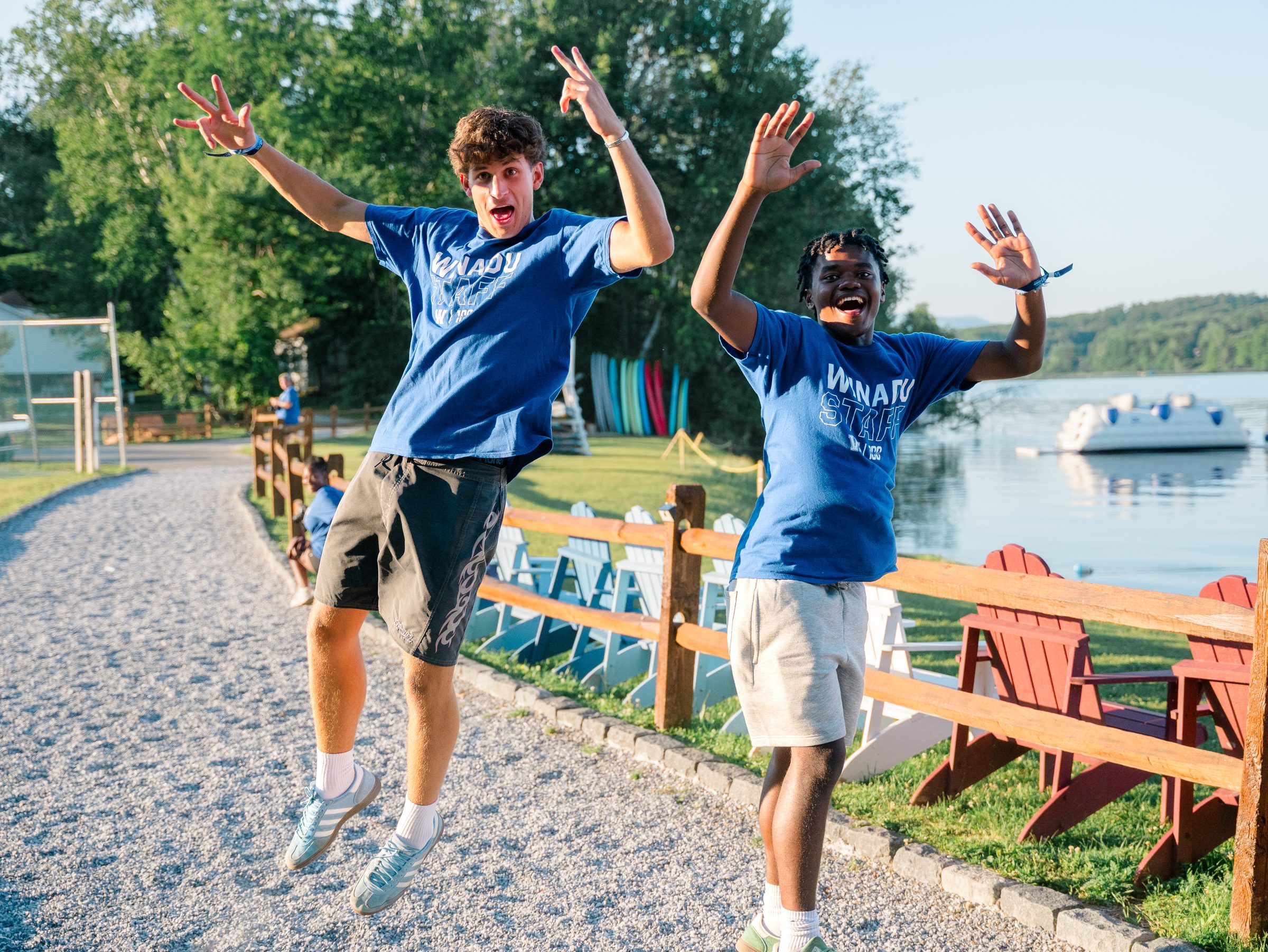Two Camp Winadu staff members jumping for joy by the lake